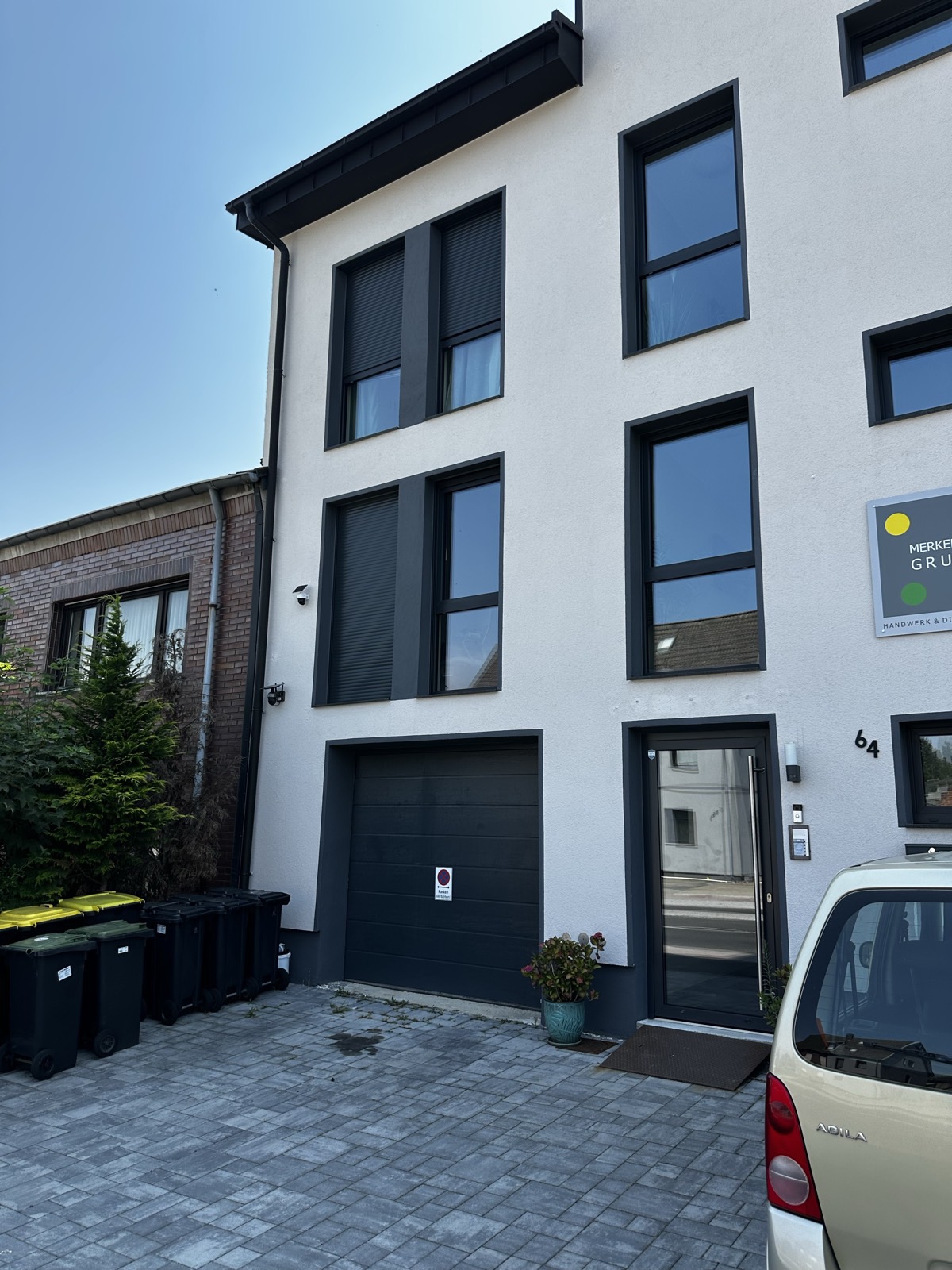 Gebäudeseite mit Garage, Rollläden und großformatigen Aluminium-Fenstern