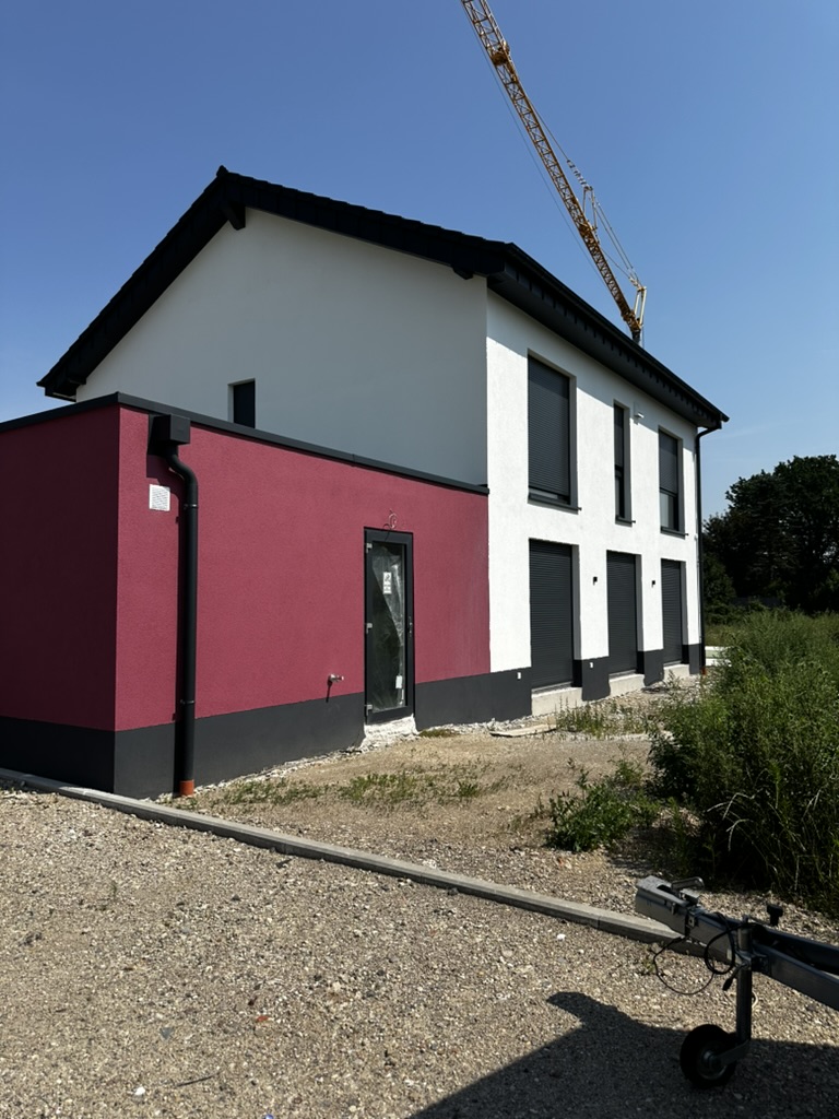 Seitenansicht mit roter Garagenwand und Seiteneingangstür