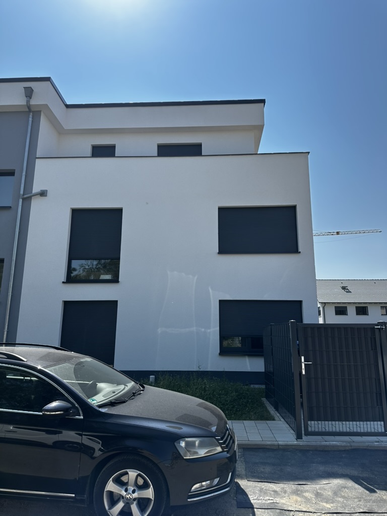 Fassadendetail mit großen Fenstern und Rollläden